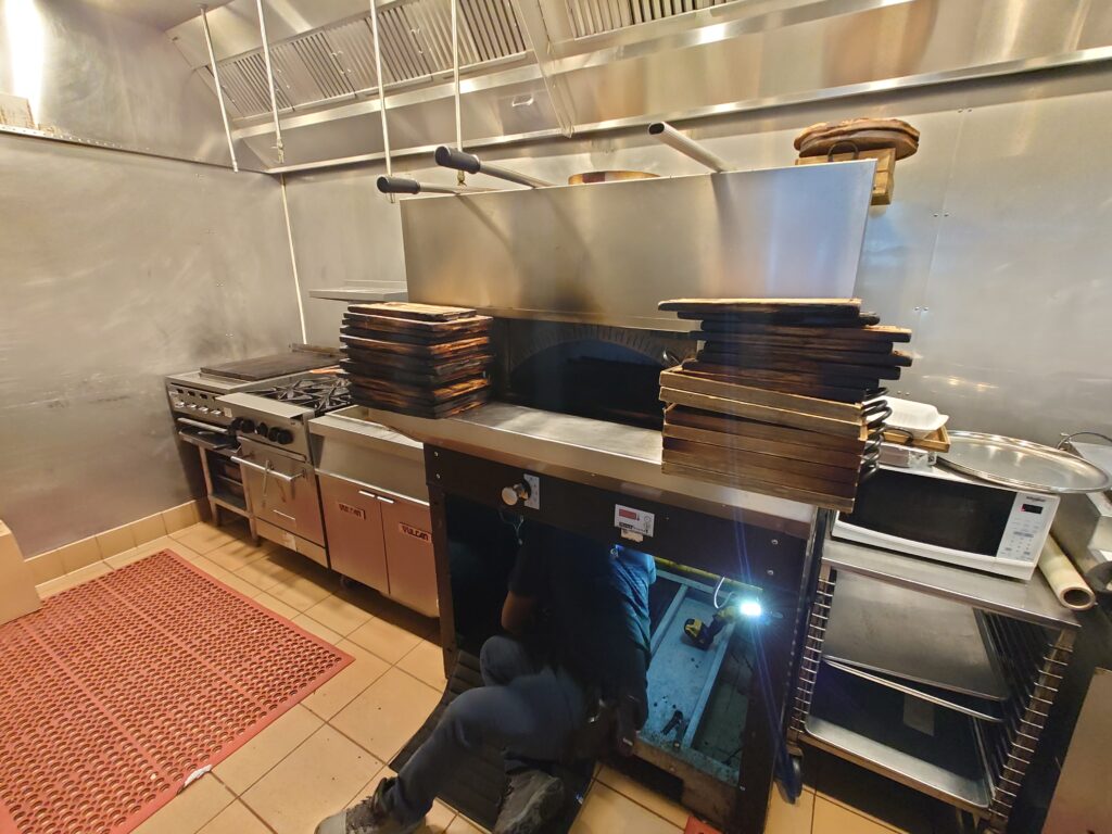 Kitchen tech working on a pizza oven